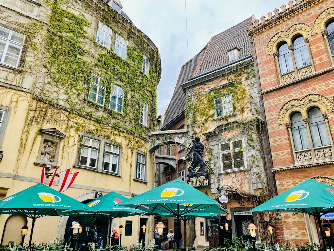 Historic Vienna street with traditional buildings and green café umbrellas